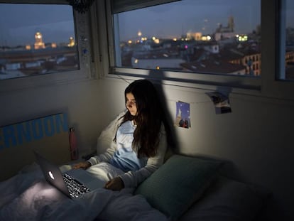 Adolescente assiste a série em seu quarto em Madri, durante a quarentena.