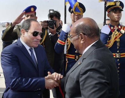 El presidente sudanés, Omar al Bashir, es recibido por el mandatario egipcio, Abdelfatá al Sisi, este domingo en el aeropuerto de El Cairo.
