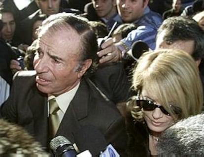 El ex presidente Carlos Menem, junto a su mujer, Cecilia Bolocco, a su llegada a los juzgados.