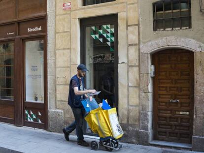 Un carter passa per davant d'un baix comercial en un carrer de Barcelona.