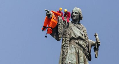 Activistas de la ONG Open Arms cuelgan en la estatua de Colón un chaleco salvavidas, el 4 de julio de 2018.