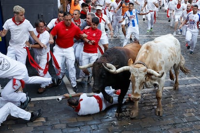 Un mozo cae al suelo durante el segundo encierro de los Sanfermines, este lunes por las calles de Pamplona. 
