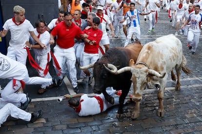Un mozo cae al suelo durante el segundo encierro de los Sanfermines, este lunes por las calles de Pamplona.