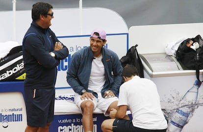 Spanish tennis player Rafael Nadal is assisted with his knee bandage as he talks to his uncle and coach Toni Nadal (L) before a training session at country club Las Salinas in Vina del Mar City, about 121 km (75 miles) northwest of northwest of Santiago, February 4, 2013. Nadal is keeping his expectations low ahead of his long-awaited return to competitive action on February on the VTR Open tournament in the coastal city of Vina del Mar, after seven months out of tennis with a knee injury. The 26-year-old French Open champion has not played since losing to Czech Lukas Rosol in the second round at Wimbledon in June due to a partial tear of the patella tendon and inflammation in his left knee. REUTERS/Eliseo Fernandez (CHILE - Tags: SPORT TENNIS)
