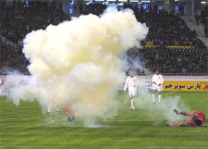 El jugador norcoreano So Hyok Chol cae al césped del Azadi Stadium tras el lanzamiento de la bengala.