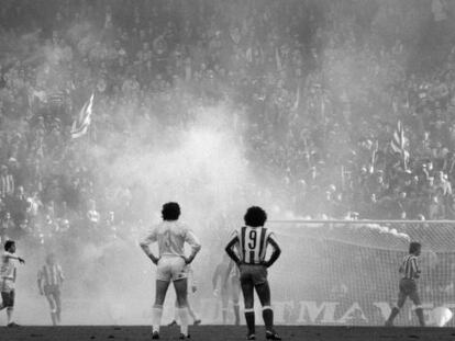 Los jugadores, rodeados del humo provocado desde la grada durante el Atlético-Real Madrid.