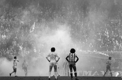 Los jugadores, rodeados del humo provocado desde la grada durante el Atlético-Real Madrid.