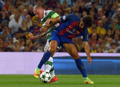 Scott Brown (i) del Celtic y André Gomes del Barcelona luchan por el balón.