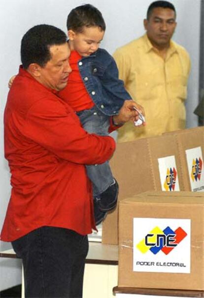 El presidente venezolano, Hugo Chávez, vota en Caracas con su nieto en brazos.