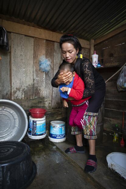 La familia tiene una letrina con un bidón de agua donde cada mañana Khamphout asea al pequeño Kum, que siempre se queja y protesta.