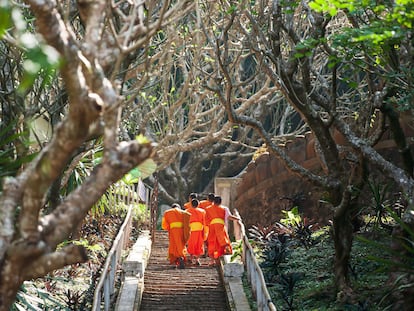 2CBPXJK Back view of Buddhist novice monks walking up stairway to Phou Si summit. Luang Prabang, Laos. UNESCO world heritage town.