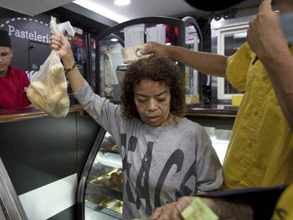 Clientes compram pão subsidiado em uma confeitaria de Caracas