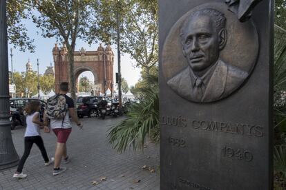 Dos personas caminan cerca de una placa en honor a Lluìs Companys en Barcelona.