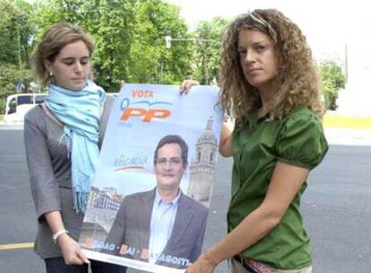 Nerea Alzola (derecha) y Virginia Arroyo sostienen un cartel de Antonio Basagoiti como los que estaban pegando cuando fueron agredidas.