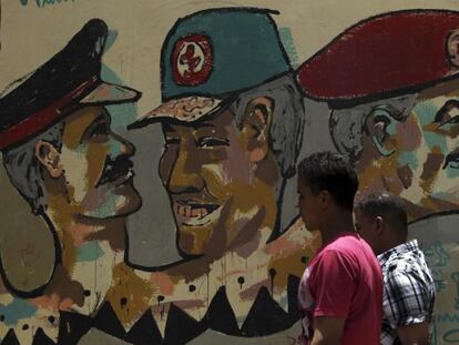 Dos transeúntes, ante un grafiti de miembros de la Junta Militar, en El Cairo.