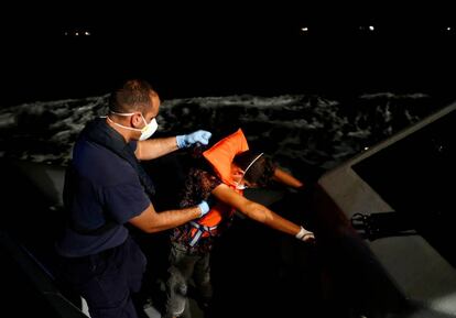 Un migrante tunecino es ayudado por un oficial maltés.