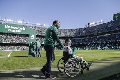 Manuel Morales acompaña a un aficionado bético antes de un partido en el estadio Benito Villamarín.