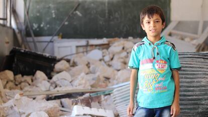 Un niño en un aula destruida en Siria.