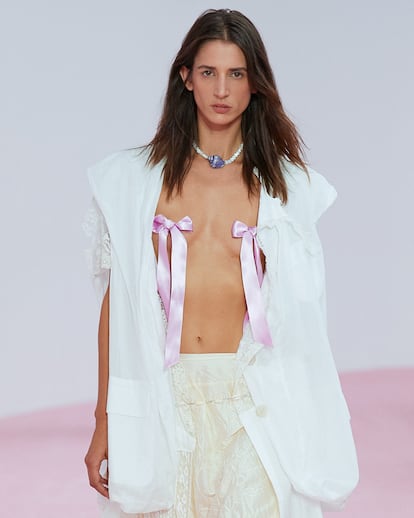 Balletcore. Acne Studios tiene la solución para poner fin a la censura de Instagram por mostrar el pezón femenino ha llegado. En su desfile PV 2023 propone convertir un broche en forma de lazo con cinta de ballet en absoluto y único protagonista del torso, sustituyendo a cualquier prenda superior.