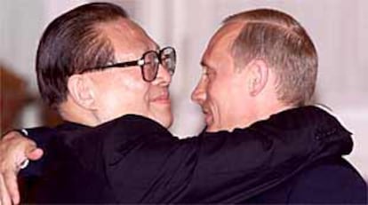 El presidente chino, Jian Zemin, y el presidente ruso, Vladímir Putin, se abrazan en Moscú, tras firmar el acuerdo amistad entre los dos países.