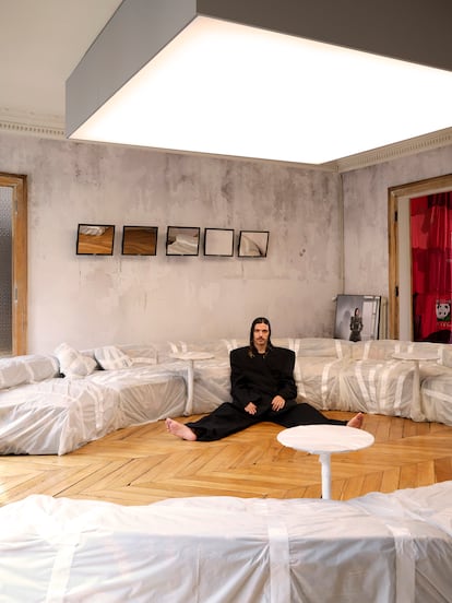 Nuriev en su salón, vestido de Balenciaga, bajo la lámpara de luz continua. Detrás, cuatro espejos hechos con monitores de ordenador.