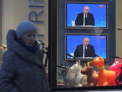 Una mujer pasa frente a dos televisores de un escaparate de una tienda de  San Petersburgo, este jueves.
