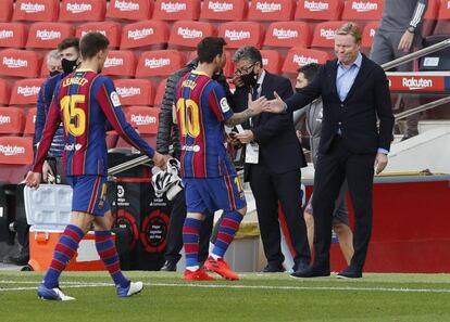 El entrenador del Barcelona,Ronald Koeman (a la derecha), da la mano a Lionel Messi al finalizar el partido.