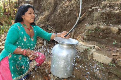 Raj Kumari Sunur, de 36 años, recoge agua tras la rehabilitación del depósito del que se abastece su aldea, en la región de Sindhupalchok. Durante meses, decenas de casas han tenido que compartir un solo grifo por el que salía escasa cantidad de líquido sucio.