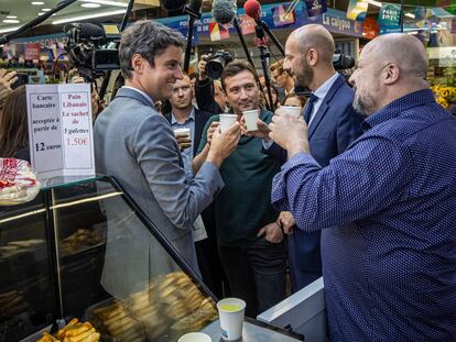 El primer ministro francés, Gabriel Attal (a la izquierda), hace campaña en un mercado en París, este martes.