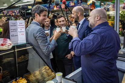 El primer ministro francés, Gabriel Attal (a la izquierda), hace campaña en un mercado en París, este martes.