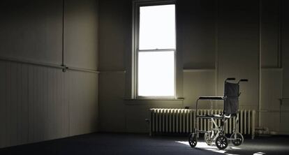  En la imagen, una silla de ruedas en una habitaci&oacute;n vac&iacute;a. 