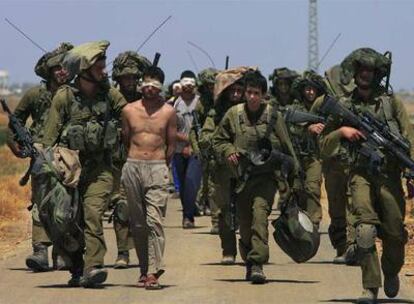 Soldados israelíes llevan a palestinos detenidos con los ojos vendados hacia la frontera entre Gaza e Israel.