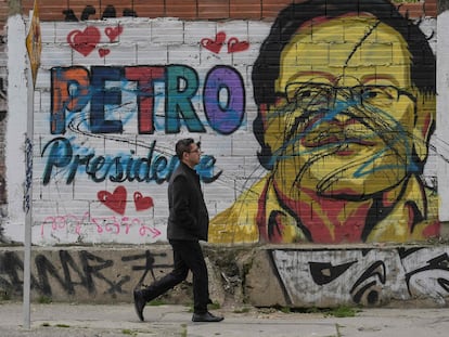 Un hombre pasa junto a un mural que representa al candidato Gustavo Petro, en Bogotá.