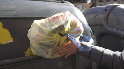 Un hombre tira la basura en Madrid. 