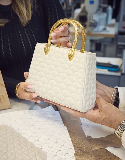 La diseñadora sujeta un bolso Serpentine Tote Matelassé en blanco, una pieza de su nueva colección de accesorios para Bulgari.