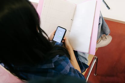 Una alumna usa su móvil dentro del aula.