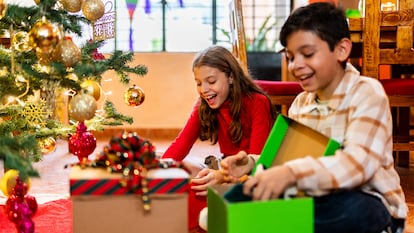 Un niño y una niña abriendo regalos