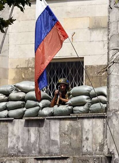 Un soldado ruso vigila la marcha de una manifestación en el exterior de su base de Teklati, cerca de Poti.