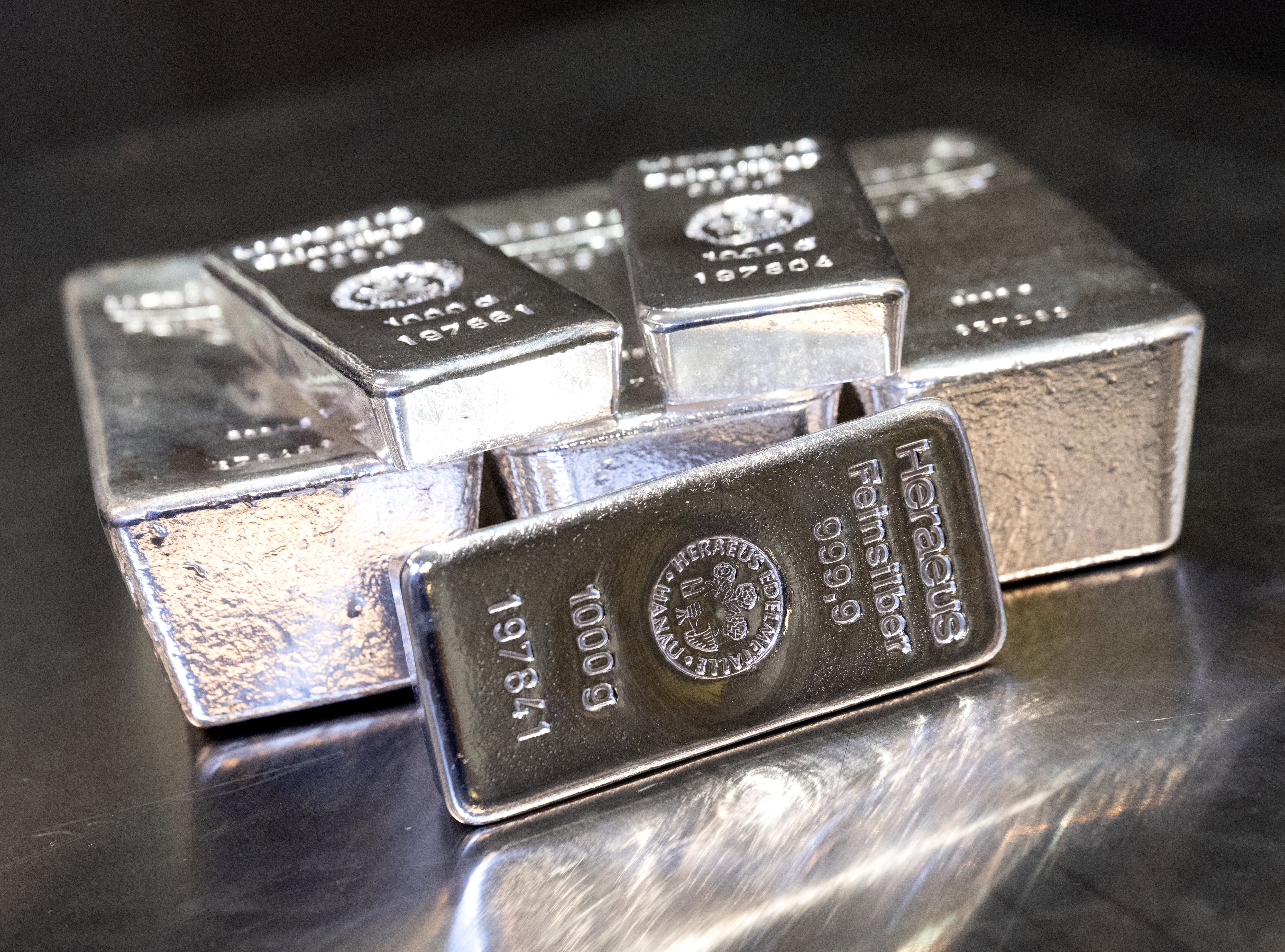 Lingotes de plata de distintos tamaños reposan en una caja fuerte sobre una mesa del distribuidor de metales preciosos Pro Aurum.