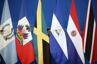 Una mujer coloca las banderas durante la primera reunión ministerial del Foro China-Países Latinoamericanos y Caribeños (Celac) celebrada en Pekín (China), el 9 de enero de 2015.