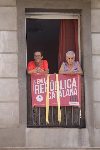 Dues dones al balcó de casa seva, on reclamen la república catalana.