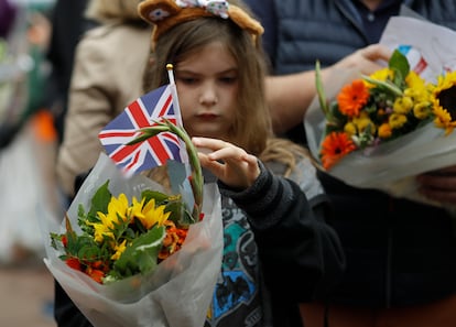 A young girl holds flowers outside Buckingham Palace in London, Britain, 10 September 2022.