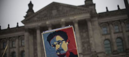 Un hombre porta un cartel de Snowden frente al edificio del Bundestag.
