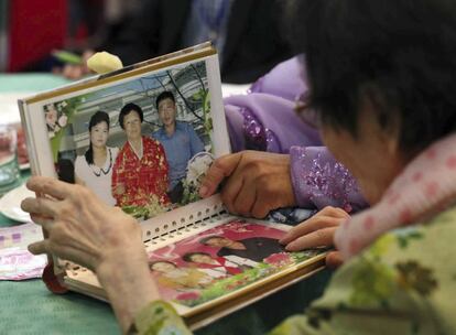 La surcoreana Han Shin-ja, 99, derecha, ve fotos de familiares de sus hijas norcoreanas durante la reunión interfamiliar.