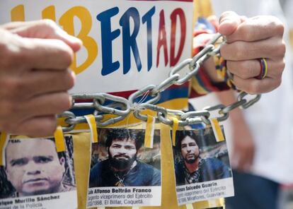 Un hombre marcha con imágenes de secuestrados por las FARC en Bogotá, Colombia.