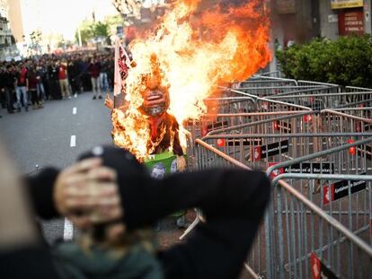 Un muñeco imitación de Mariano Rajoy arde ante la sede del PP.