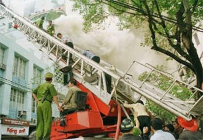 Los trabajadores de las oficinas salen por una escalera de los bomberos.