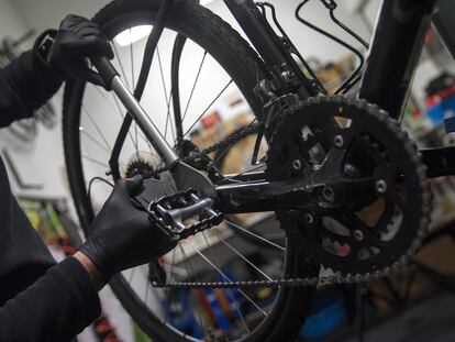 Un hombre arregla una bicicleta en un taller de Madrid.