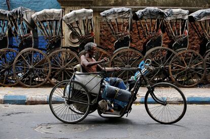 Un hombre pasa junto a una hilera de rickshaws en Kolkata (India). 