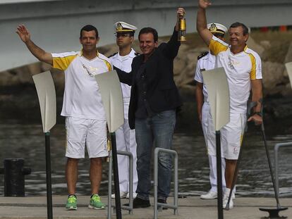 O prefeito Eduardo Paes recebe dos medalhistas olímpicos Torben (à esq.) e Lars Grael a tocha olímpica.